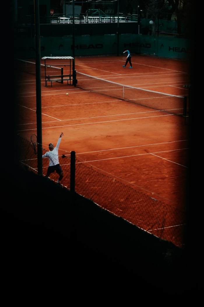 The Art of Drawing Readers In: Your attractive post title goes here A vibrant tennis match in action on a clay court with players actively engaged.