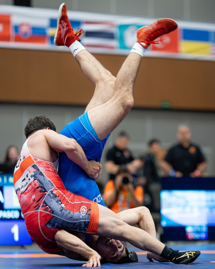 Crafting Captivating Headlines: Your awesome post title goes here Intense wrestling match capturing athletes in vibrant uniforms mid-action. A visual of athleticism and competition.